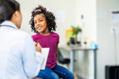 Doctor speaking to smiling child patient